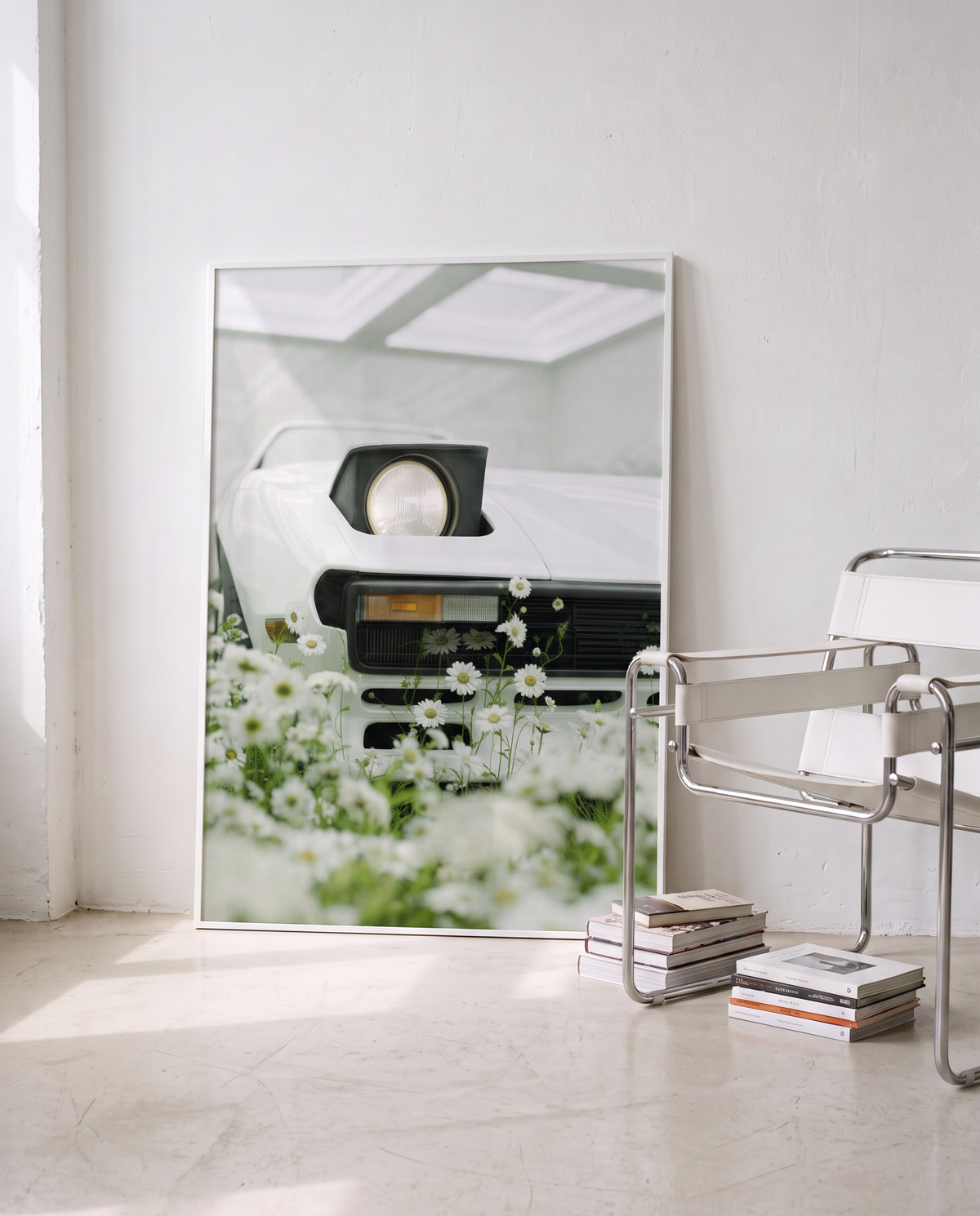WHITE 02 framed, leaning against a white wall next to a chrome chair